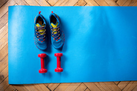 Sports running shoes and fitness gunterly. Fitness equipment on a fitness mat. Fitness at home. View from above.の写真素材