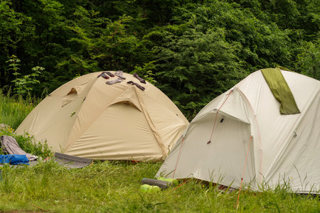 Tourist tents in the park. Hiking and tourism. Drying things on a tent. Wet clothes.の写真素材