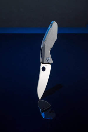 Premium quality folding pocket knife. The knife and its reflection. Knife on a black background. Brand knife. Vertical knife.の写真素材