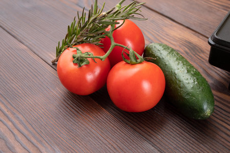 Tomatoes and cucumbers on a wooden table. A bunch of vegetables on the table. View from above.の写真素材