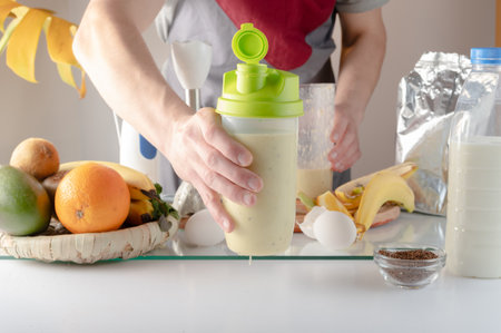 Shaker in an outstretched hand. Shaker with a cocktail in hand. Healthy food. A man holds a shaker.の写真素材