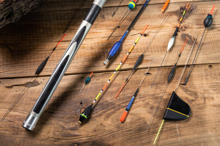 Various fishing floats on a wooden background. Fishing rod and floats on wood. Fishing composition.の写真素材