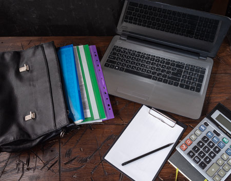 Leather briefcase with documents. Documents and laptop on the table. Financiers desk. Documents and calculator. Notepad and pencil.の写真素材