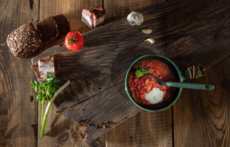 Ukrainian cuisine and still life. Ukrainian borscht with dark bread, lard and garlic. Wooden table background. Top view. Still life.の写真素材