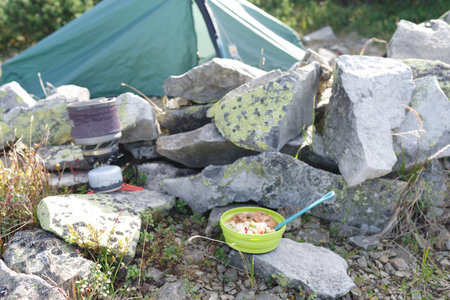 Tourist camp in the mountains. Tourist place with a tent and a field kitchen. Prepared food against the background of the tent.の写真素材
