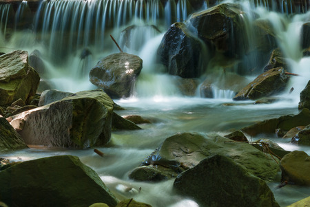 Water flowing over rocks in mountain streamの写真素材