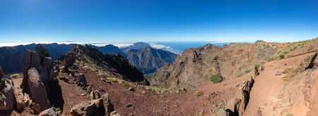 Panoramic view from the top of the mountain to the crater of the volcano. Background canyon with clouds and oceanの写真素材