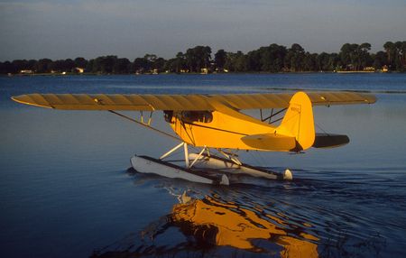 yellow floatplane on lake