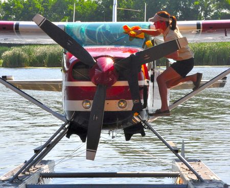 Woman preparing Seaplane for flight, Lake Winnabago, WI, July 23. 2009