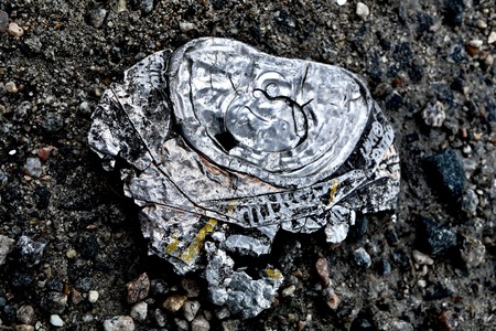 Smashed aluminum can on pavementの写真素材