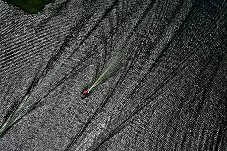 boats and their wake on a lake-aerial viewの写真素材