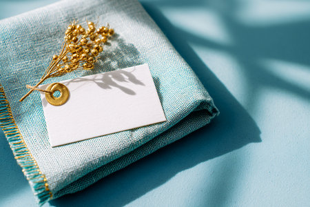 Blank greeting card on blue linen napkin. Mockup.の素材