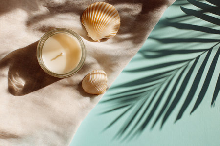 Composition with candle, seashells and towel on color backgroundの素材