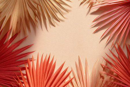 Tropical palm leaves on beige background with copy space.の素材