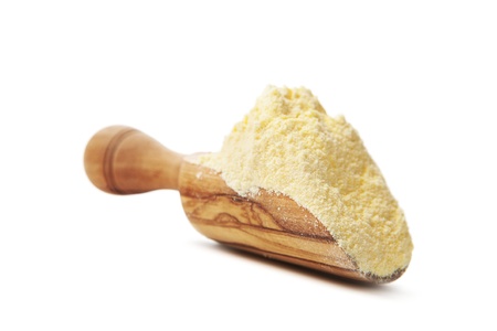 Corn flour poured from wooden scoop