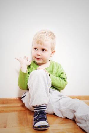 Little boy sitting on floor at homeの写真素材