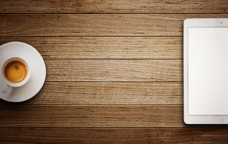 Tablet and coffee cup on wooden table -Place for advertisementの写真素材