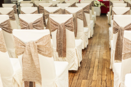 Indoors wedding reception venue with decor, selective focus on chairの写真素材