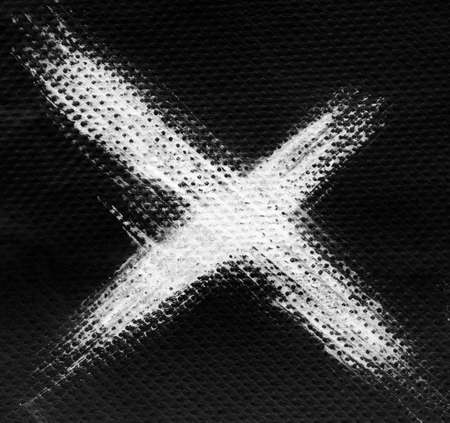 White X ink letter on black background, napkin tissue textureの写真素材