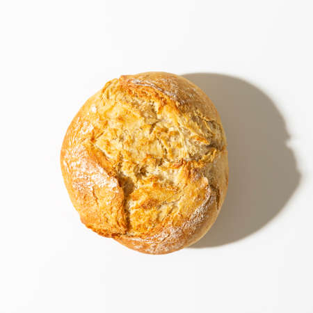 Crusty round bread roll, known as Kaiser or Vienna roll on white background