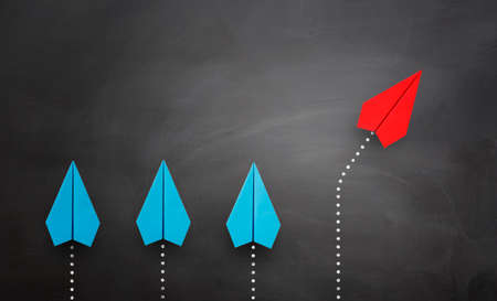 Red paper plane leading a group of blue paper planes changes direction, Business concept