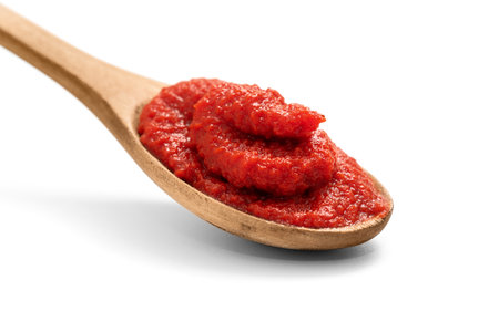 Natural tomato puree in wooden spoon isolated on white, including clipping pathの写真素材