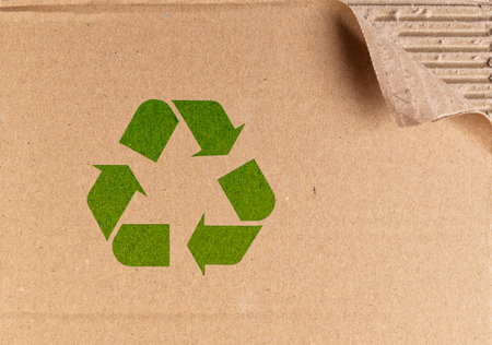 Recycling symbol on brown cardboard packing box. Concept of eco awareness, paper reuse and green thinkingの写真素材
