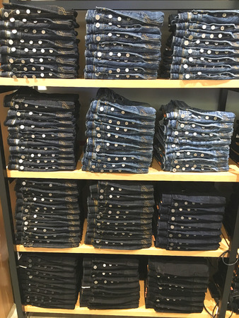 Jeans trousers on the shelf at the shopping centreの写真素材