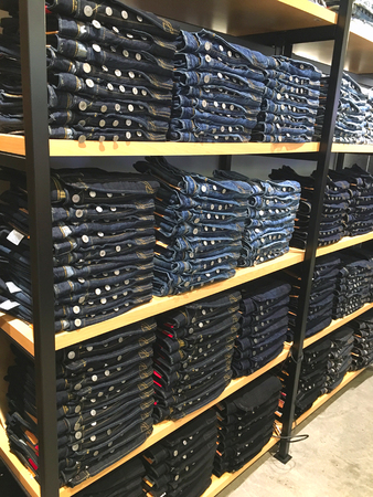 Jeans trousers on the shelf at the shopping centreの写真素材