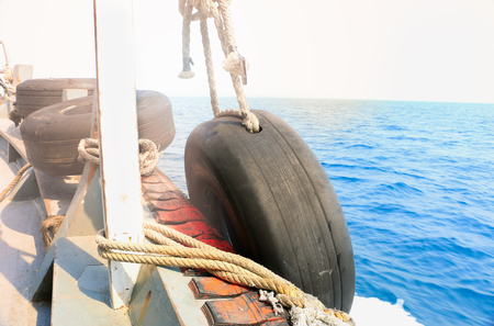Rubber wheel on the transportation boat for moor, Tire tied to a boat moored at the dockの写真素材