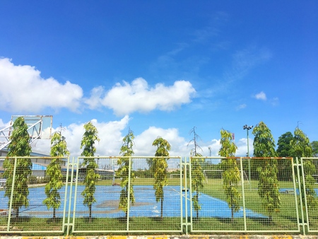 Beatiful blue sky on the basketball sport field with tree fence background in summer in thailandの写真素材