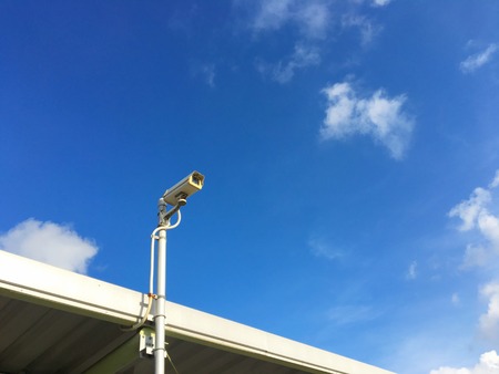 CCTV security camera on the beautiful blue sky backgroundの写真素材