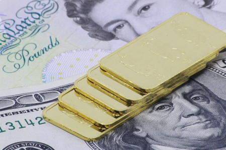 Gold bar ingot close up on the US money dollar backgroundの写真素材