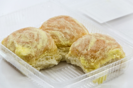 Buttered bread in a plastic box on a white background.の写真素材