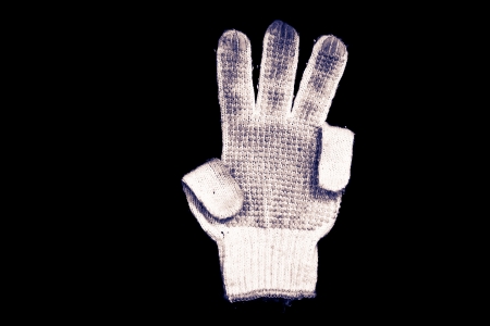 Old gloves on a black background の写真素材