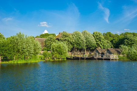 View over the lake Wallsee toward the slavic village of the Wallmuseum in Oldenburg in Holsteinのeditorial素材