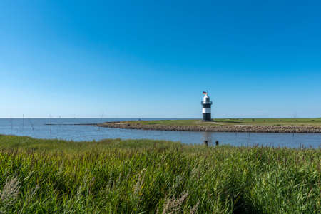 Coastal landscape with the lighthouse Little Prussian in Wremen. Wremen is located in East Frisia on the German North Sea coast.の素材 [FY310172722260]