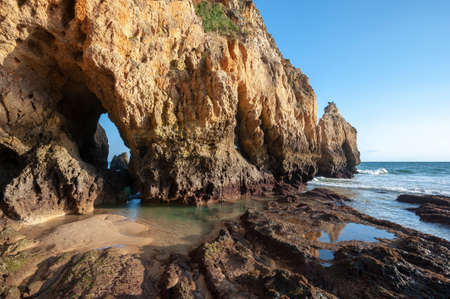 Praia dos Tres Irmaos, rocky landscape on the beach of Alvor in the Algarve in Portugal