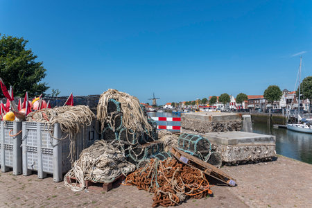 Fish traps, ropes and buoys at the quay Nieuwe Haven, in the background the windmill Den Haas in Zierikzee. Province of Zeeland in the Netherlandsの写真素材