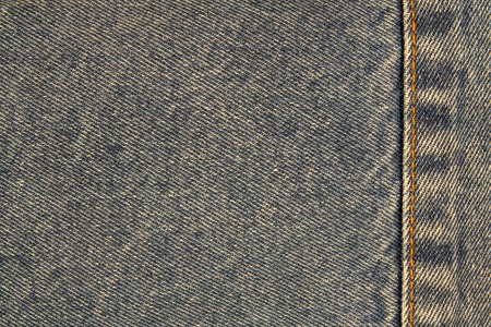 Yellow seam on a denim jeans texture for background or space for text or imageの写真素材