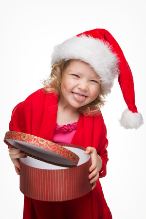 Happy little girl in red Santa hat with presentの写真素材