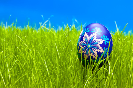 Blue Easter Egg on the grass with blue sky