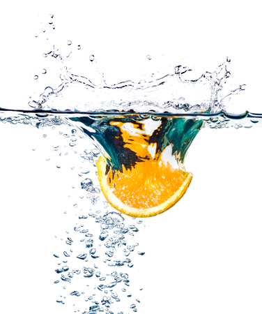 Orange slices falling into the water isolated on whiteの写真素材