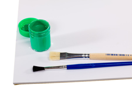 Gouache paint cans and brush with blank paper isolated on white backgroundの写真素材