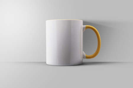 white mug with a yellow handle isolated on white backgroundの写真素材