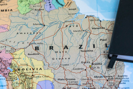 personal lanning notes of a traveller planning a trip to Brazil over a closeup map of Brazilの写真素材