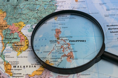 Map of the Philippines through magnifying glass on a world map.のeditorial素材