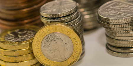 Close up focus photos of new United kingdom Pound coin, among other British coinsの写真素材