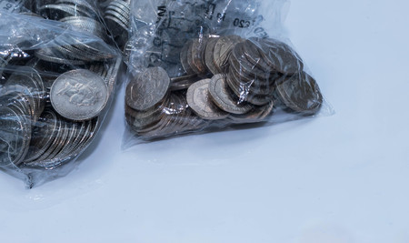 British coins in bank coing collecting plastic bags on a white background.