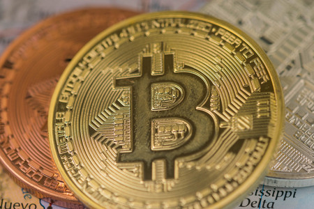 Golden Bitcoin Coin close up together with silver bitcoin and bronze bitcoin with blurred background...